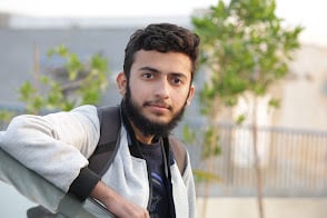 Hunain coding at his workstation with dual monitors